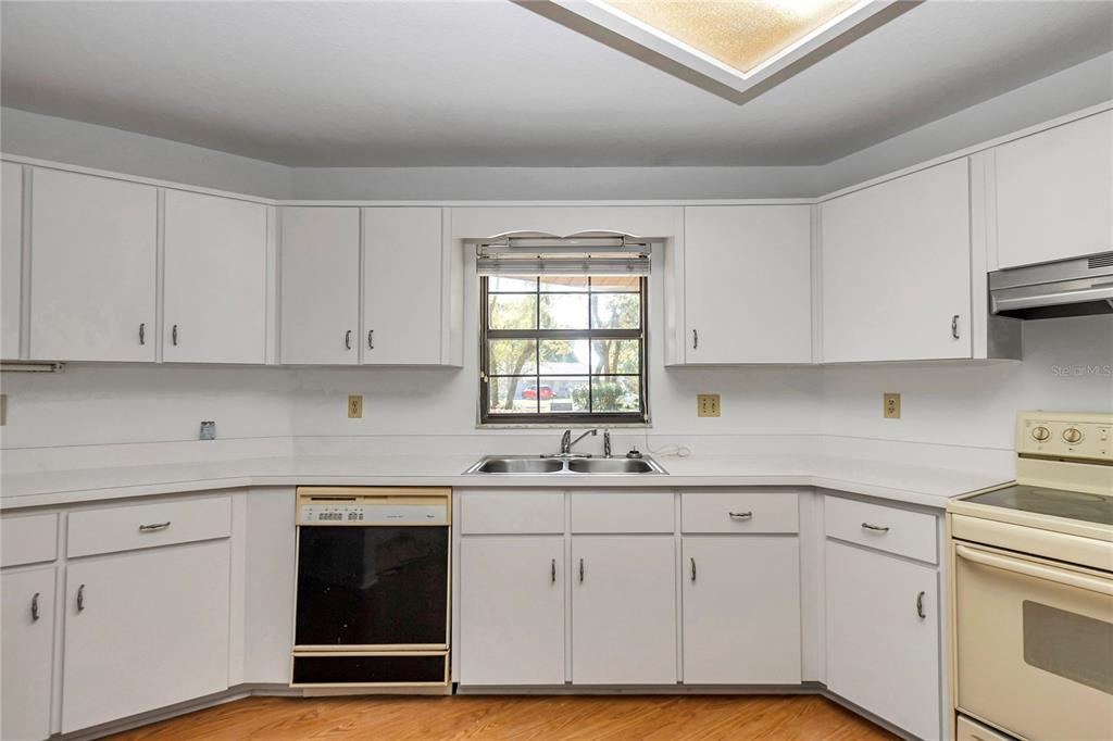 8160 Southwest 53rd Court Ocala, FL 34476 - Photo 28 of 54 a kitchen with white cabinets appliances a sink and a window