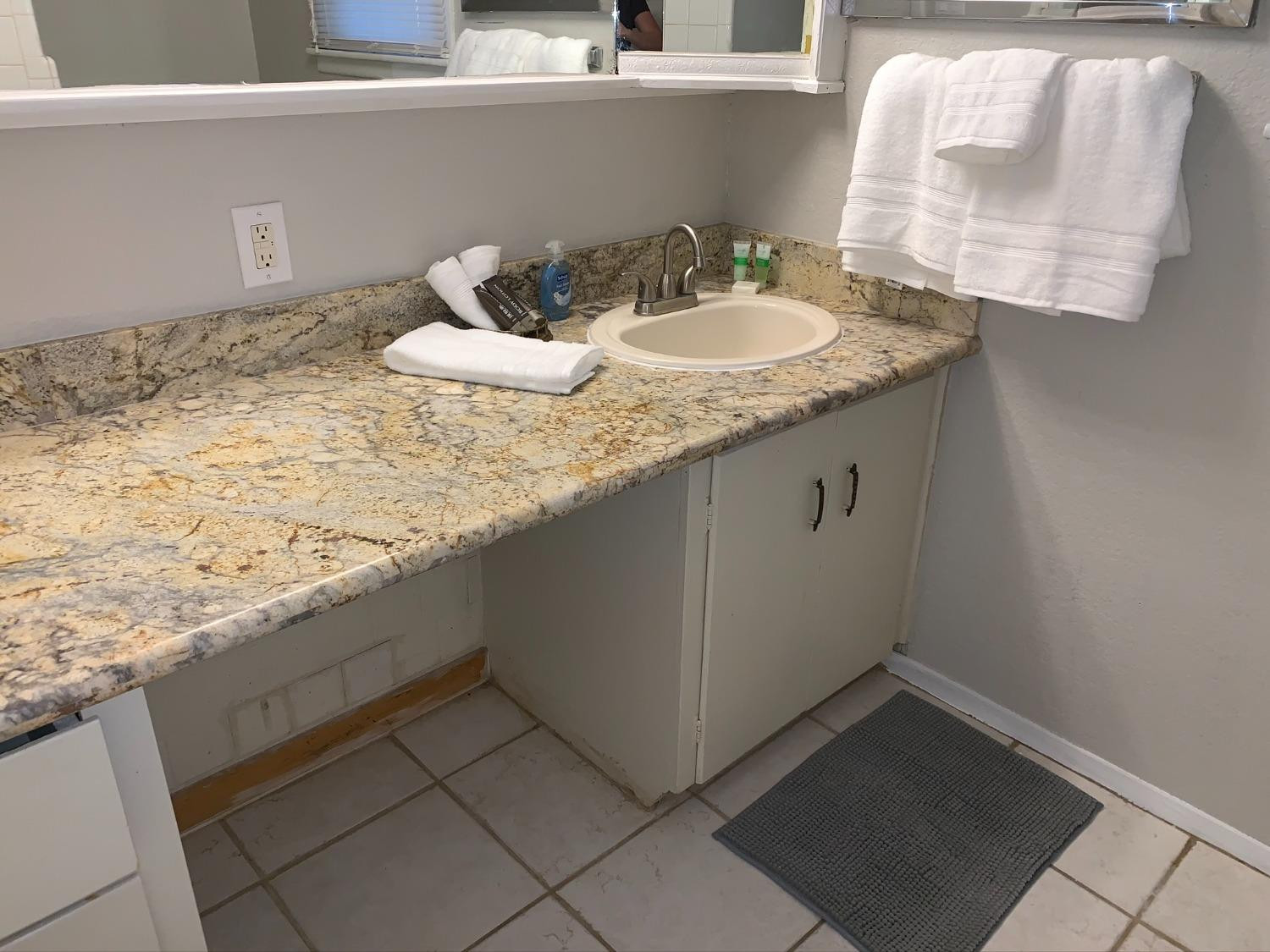 5009 16th Street Lubbock, TX 79416 - Photo 14 of 16 a bathroom with a granite countertop sink and a mirror