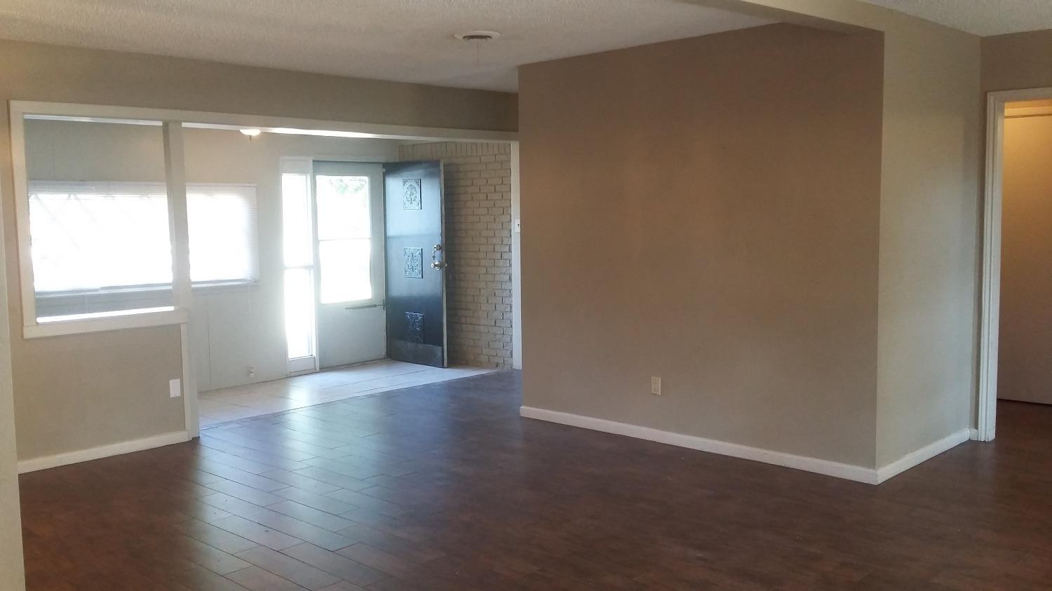 5009 16th Street Lubbock, TX 79416 - Photo 15 of 16 an empty room with wooden floor and windows