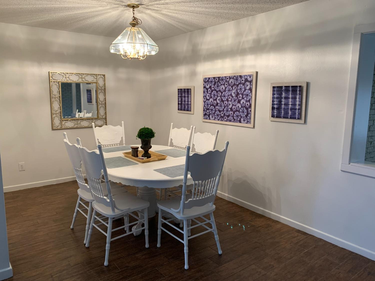 5009 16th Street Lubbock, TX 79416 - Photo 3 of 16 a dining room with furniture wooden floor and a chandelier