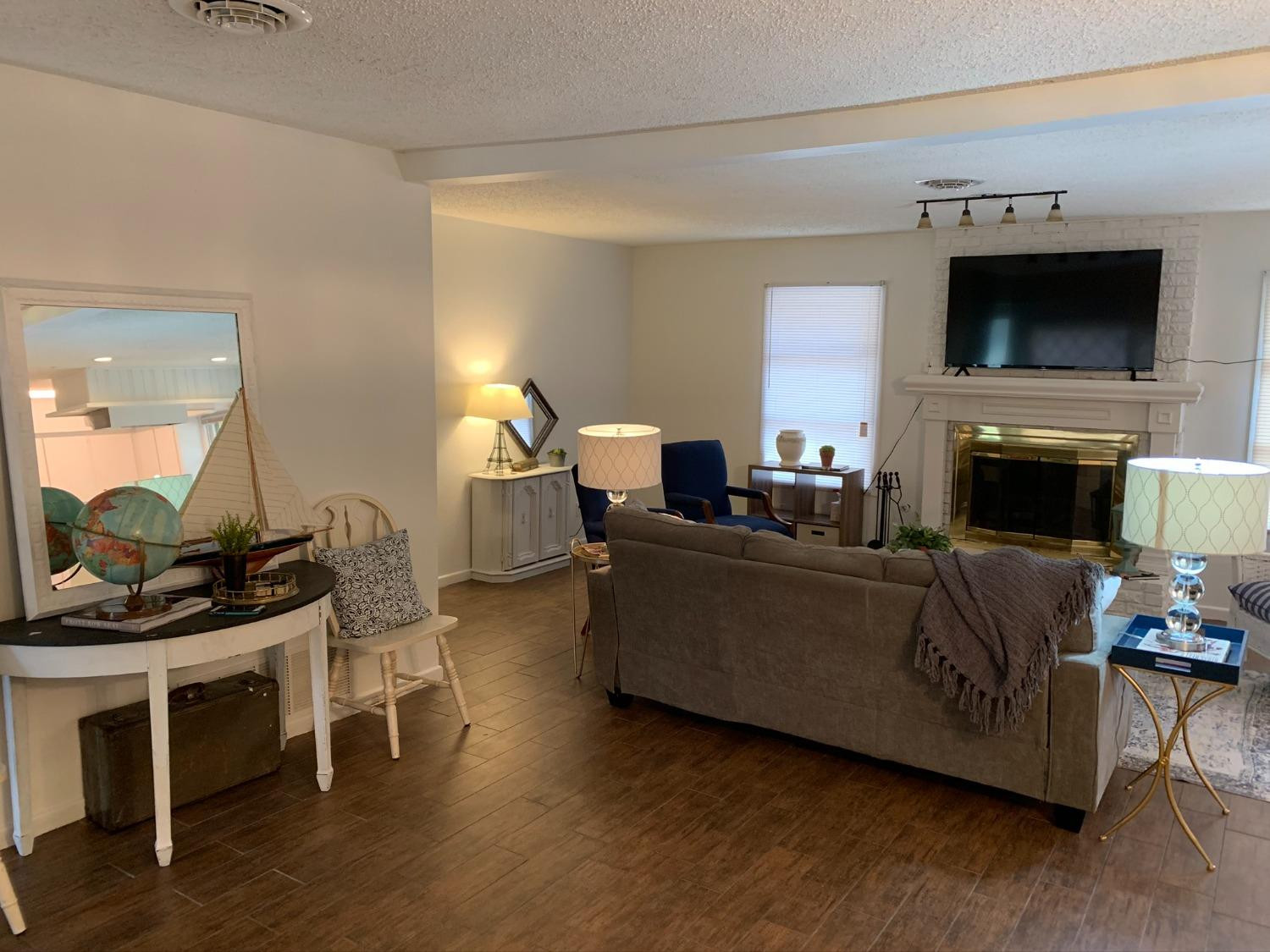 5009 16th Street Lubbock, TX 79416 - Photo 7 of 16 a living room with furniture a flat screen tv and a fireplace