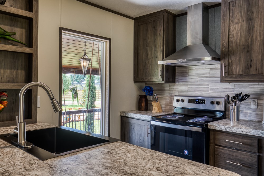 35418 Tompkins Road Hempstead, TX 77445 - Photo 12 of 50 a kitchen with stainless steel appliances granite countertop a stove a sink and a microwave
