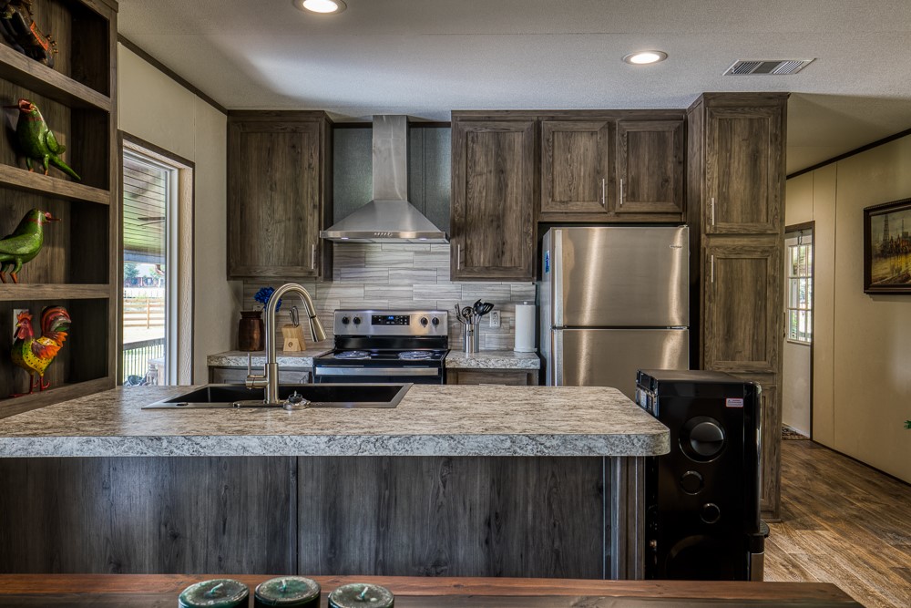 35418 Tompkins Road Hempstead, TX 77445 - Photo 14 of 50 a kitchen with kitchen island a stove a refrigerator and a counter top space