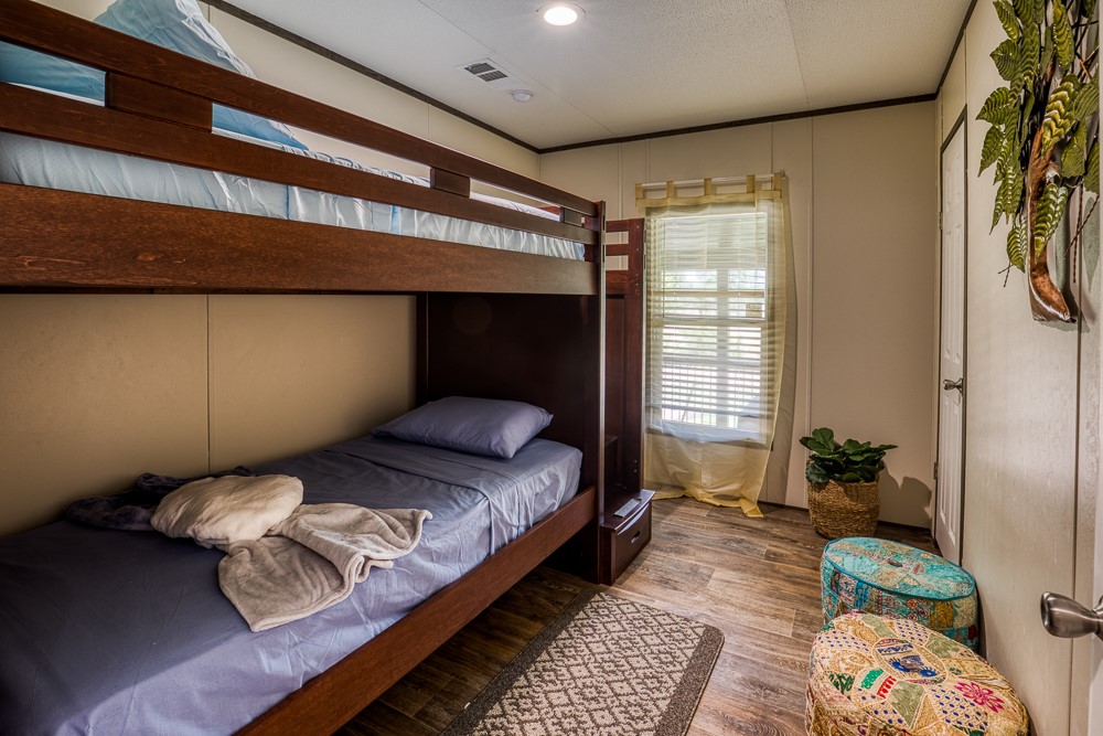 35418 Tompkins Road Hempstead, TX 77445 - Photo 20 of 50 a bedroom with a bed lamp and a large window