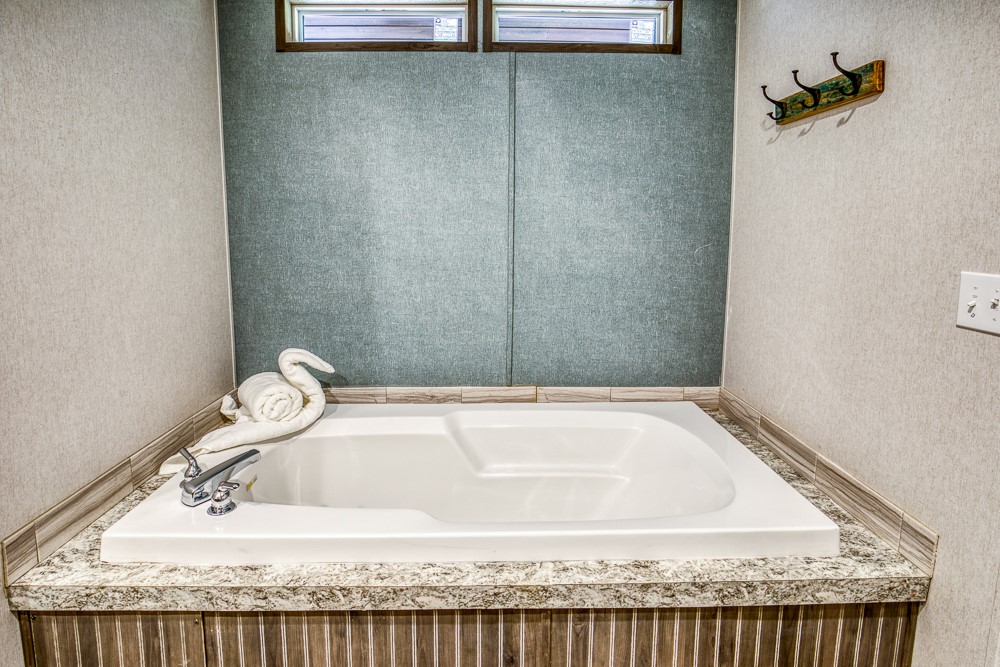 35418 Tompkins Road Hempstead, TX 77445 - Photo 26 of 50 a bathroom with a granite countertop sink and bathtub