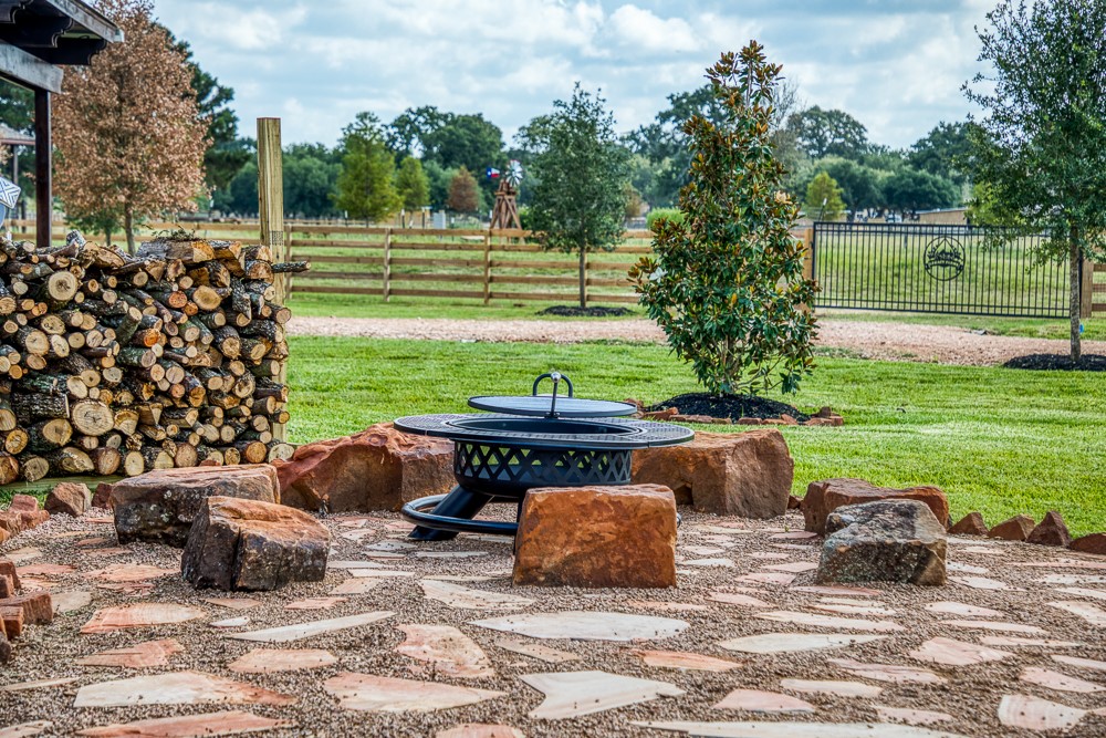 35418 Tompkins Road Hempstead, TX 77445 - Photo 33 of 50 a view of a backyard with table and chairs potted plants and a palm tree