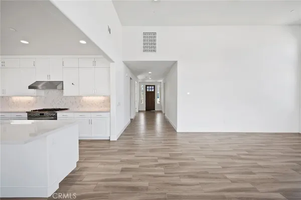 a white kitchen with kitchen island white cabinets and stainless steel appliances