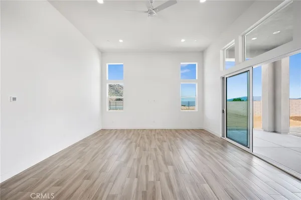 a large kitchen with stainless steel appliances a large counter top a wooden floors and a large window