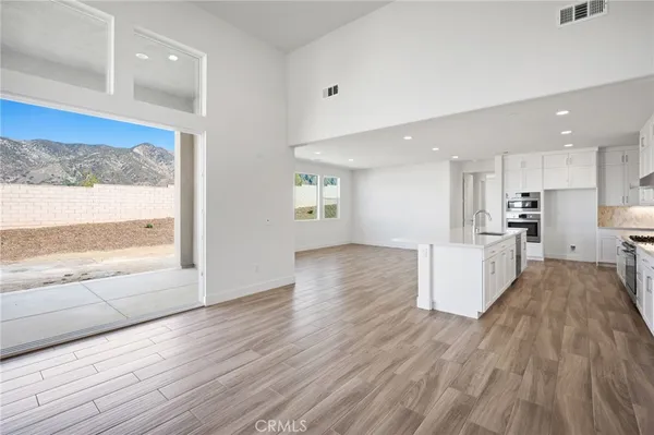 a kitchen with granite countertop a sink a counter top space stainless steel appliances and windows