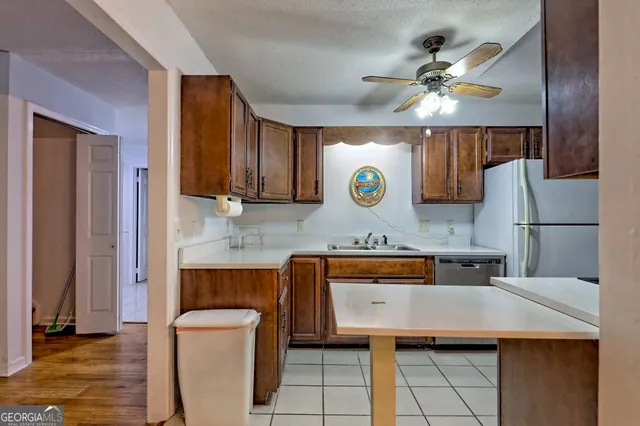 a kitchen with stainless steel appliances granite countertop a sink and a refrigerator