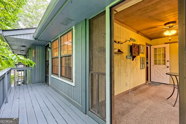 a view of a porch with wooden floor and outdoor seating