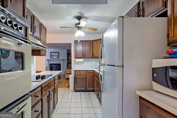 a kitchen with stainless steel appliances granite countertop a refrigerator a stove and a sink with cabinets