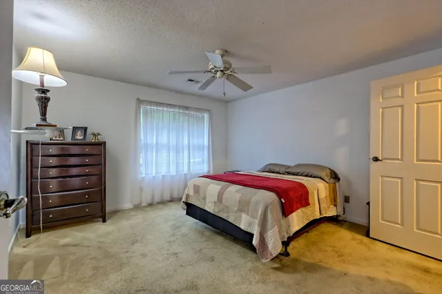a spacious bedroom with a bed and a chandelier