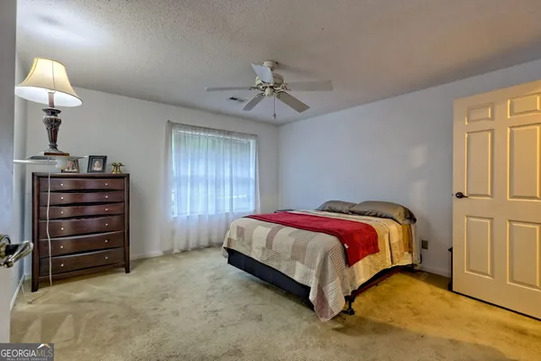a spacious bedroom with a bed and a chandelier