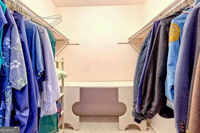 a view of walk in closet with clothes and shoes