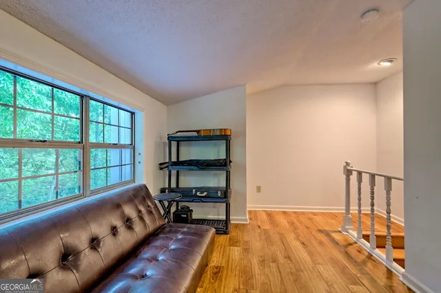 a view of a livingroom with wooden floor and furniture