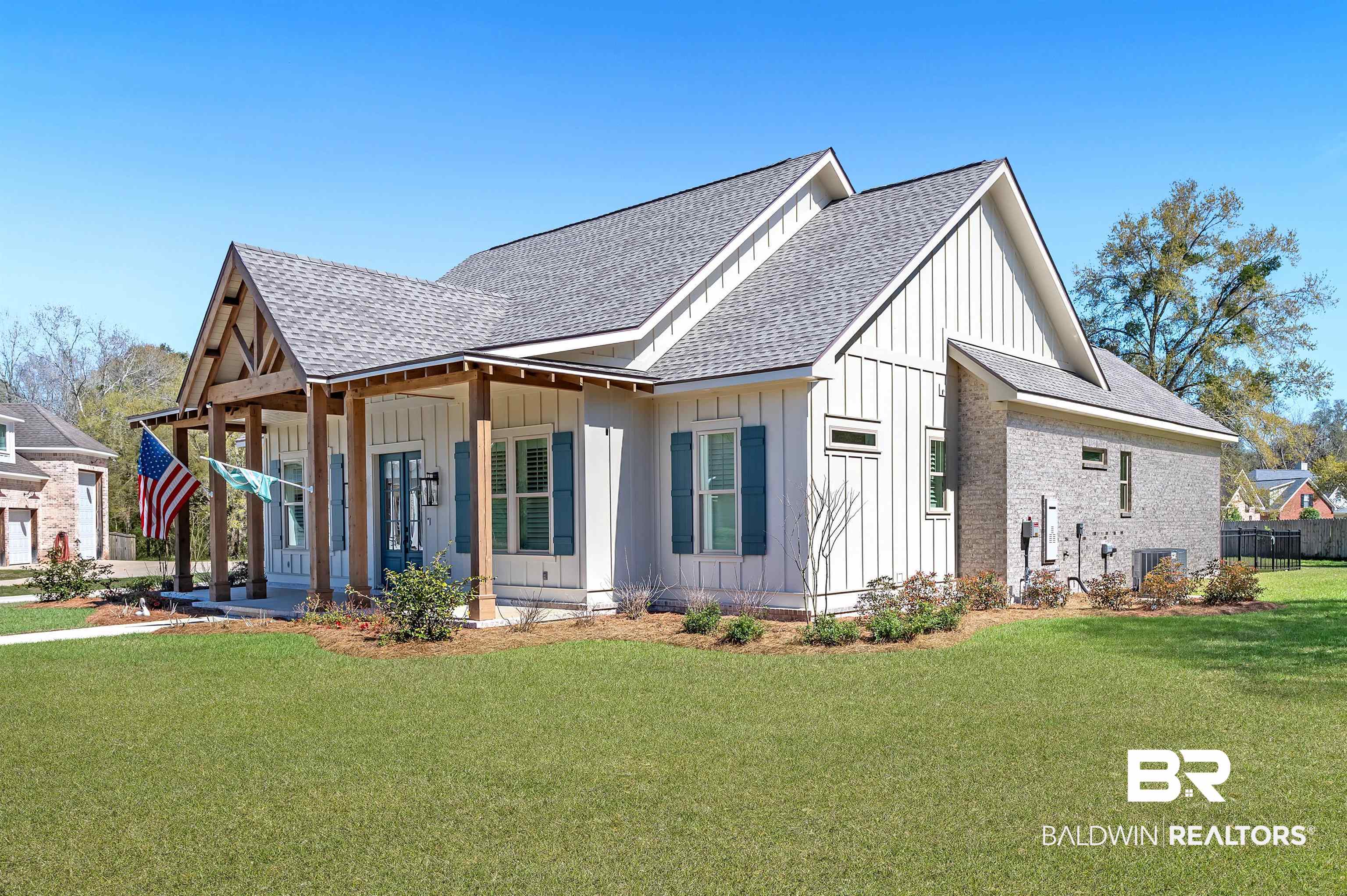 9144 Harvest Ridge Fairhope, AL 36532 - Photo 15 of 58 View of front of home with central air condition unit, board and batten siding, a front lawn, a porch, and a shingled roof