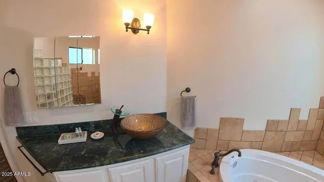 a bathroom with a granite countertop sink and a mirror
