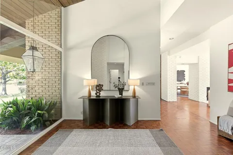 a view of a hallway with wooden floor and a living room