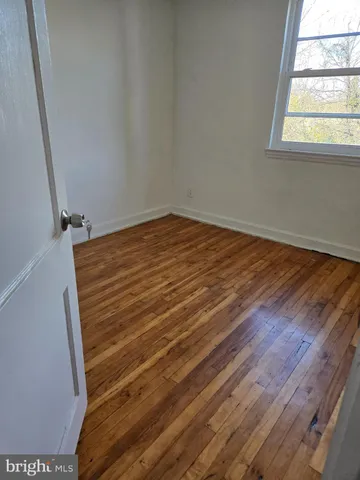 a view of a room with wooden floor and window
