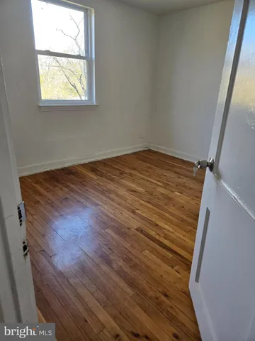 a view of a small space with wooden floor and a window