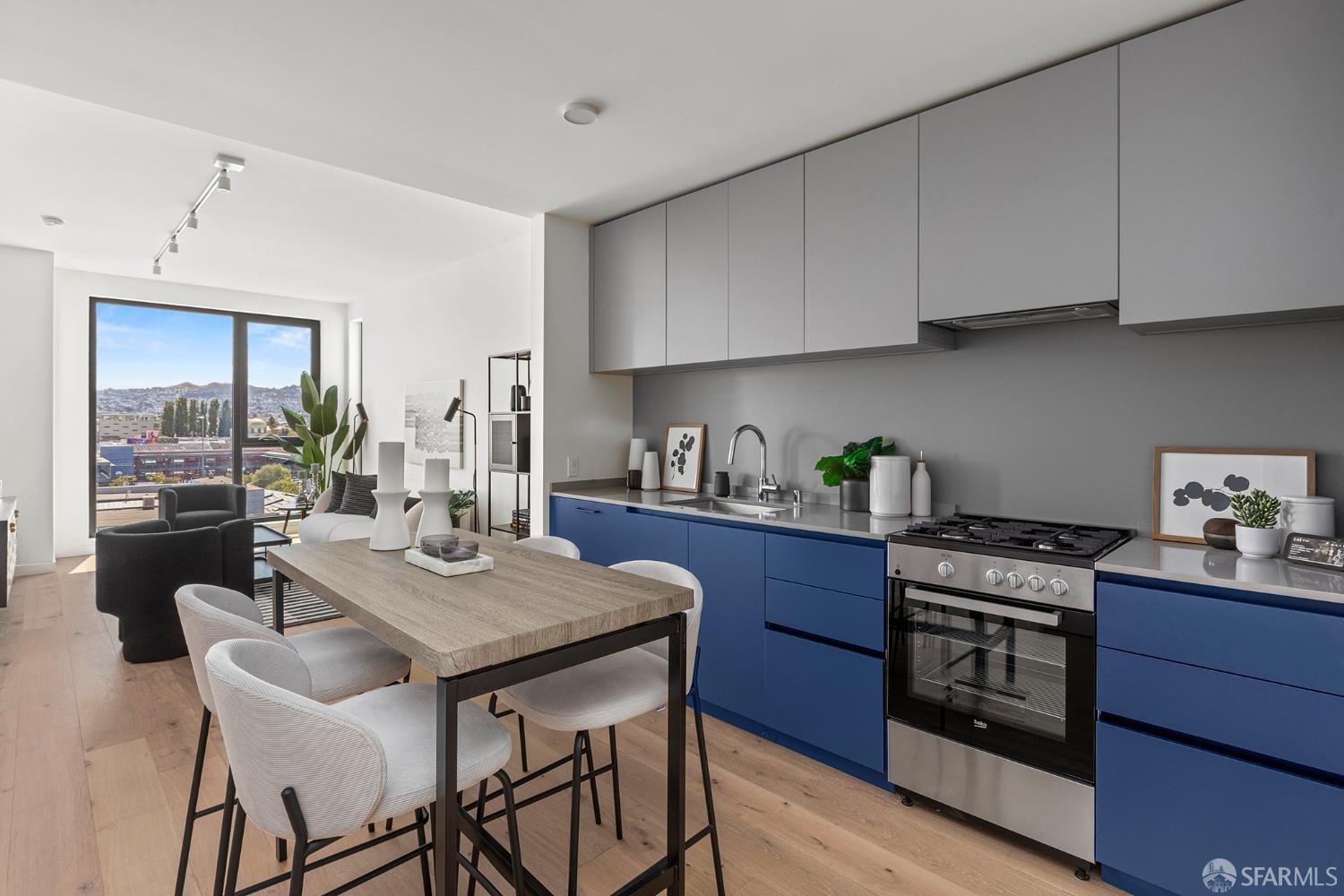 988 Harrison Street, Unit CJ3 San Francisco, CA 94107 - Photo 8 of 9 a kitchen with stainless steel appliances granite countertop a stove a sink dishwasher and cabinets with wooden floor