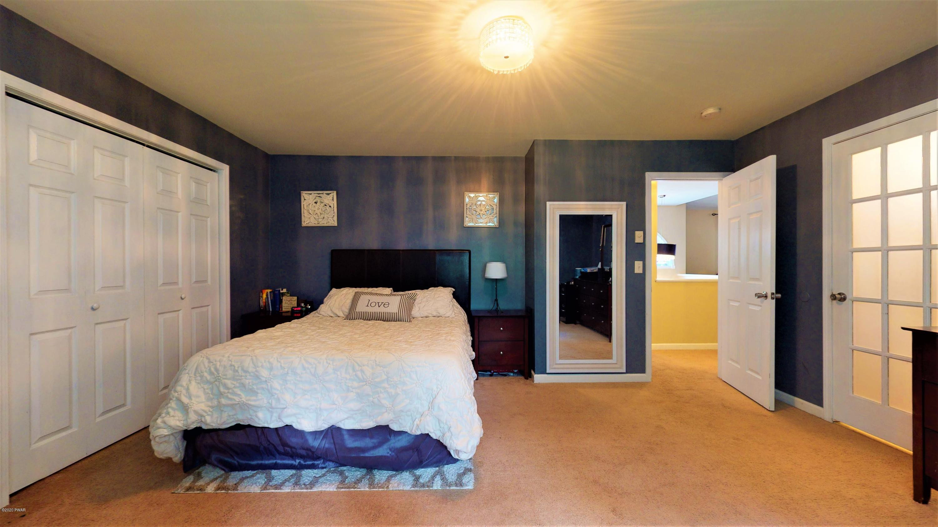 143 Raccoon Road Dingmans Ferry, PA 18328 - Photo 64 of 87 a bedroom with a bed and a chandelier