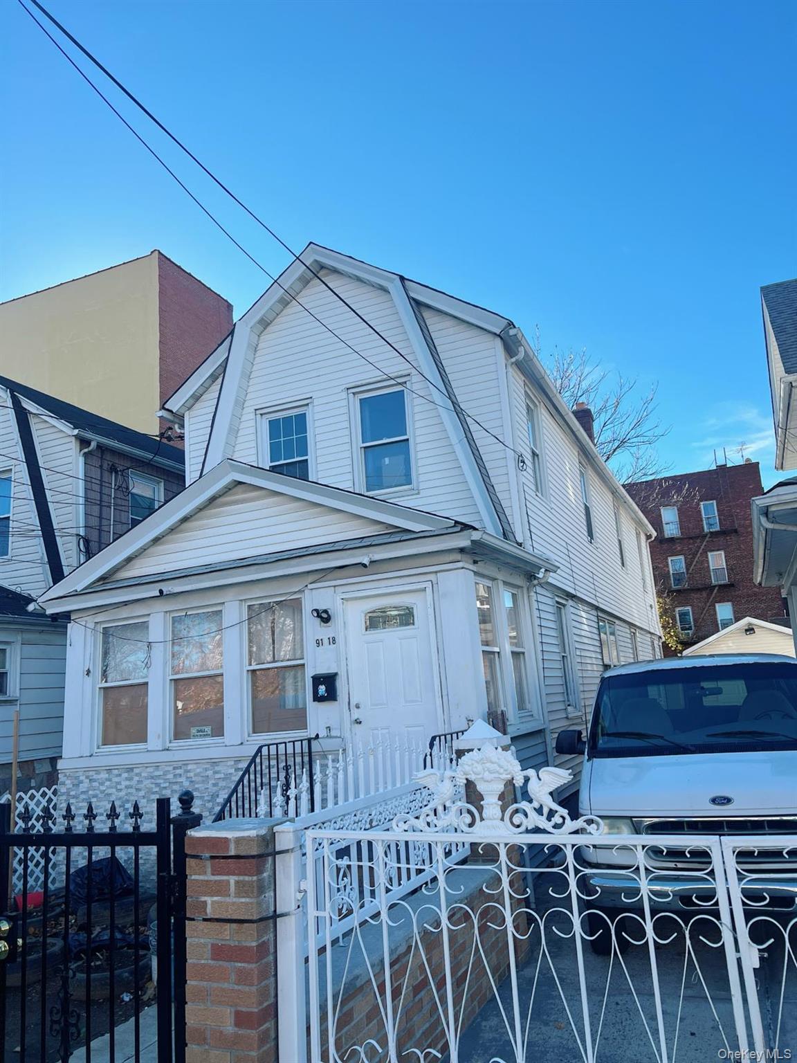 Dutch colonial featuring a fenced front yard, a gambrel roof, and a gate