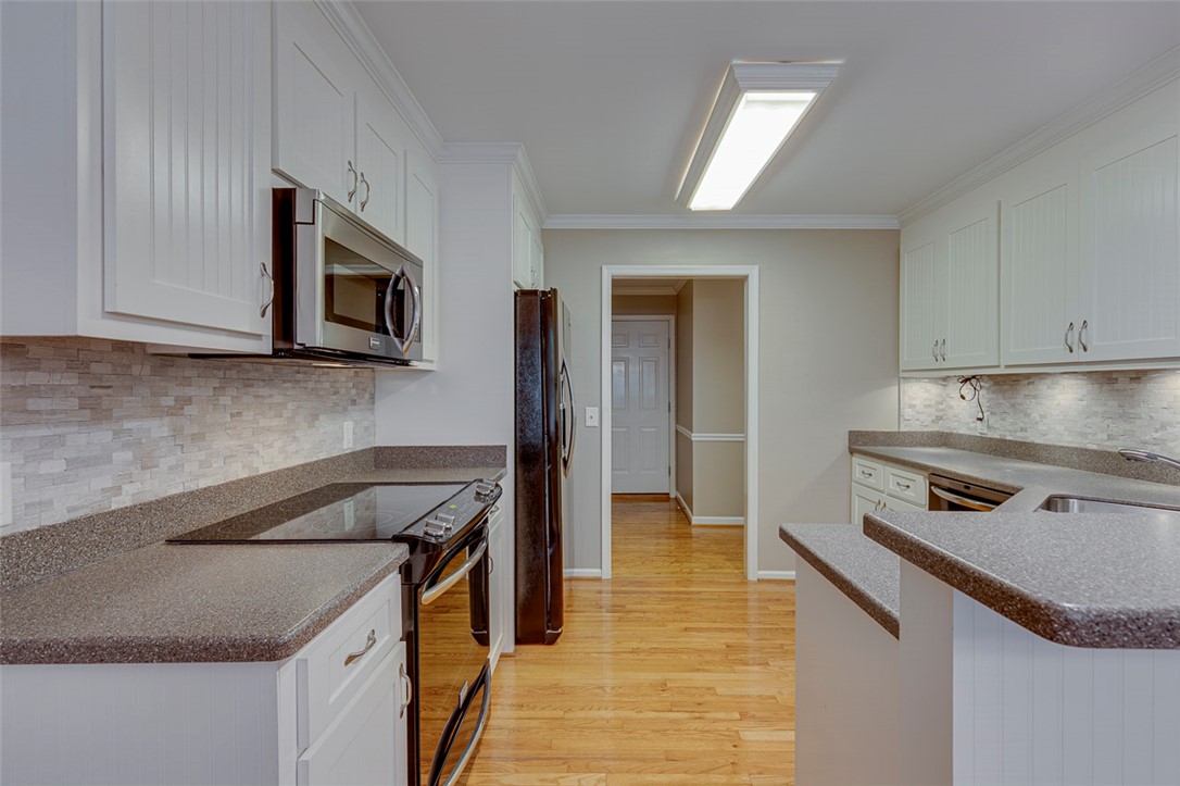 302 Wild Rice Drive Simpsonville, SC 29681 - Photo 13 of 44 Rich hardwood flooring anchors this classic workspace, bordered by timeless crown molding and pristine white cabinetry.