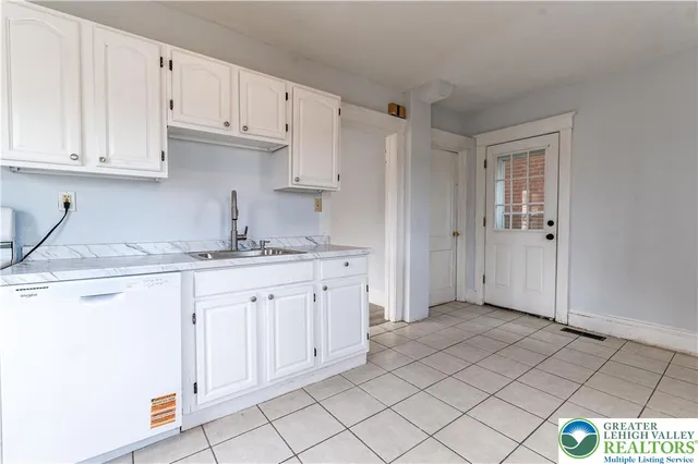a kitchen with granite countertop white cabinets and stainless steel appliances