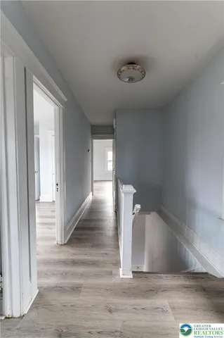 a view of entryway and hall with wooden floor