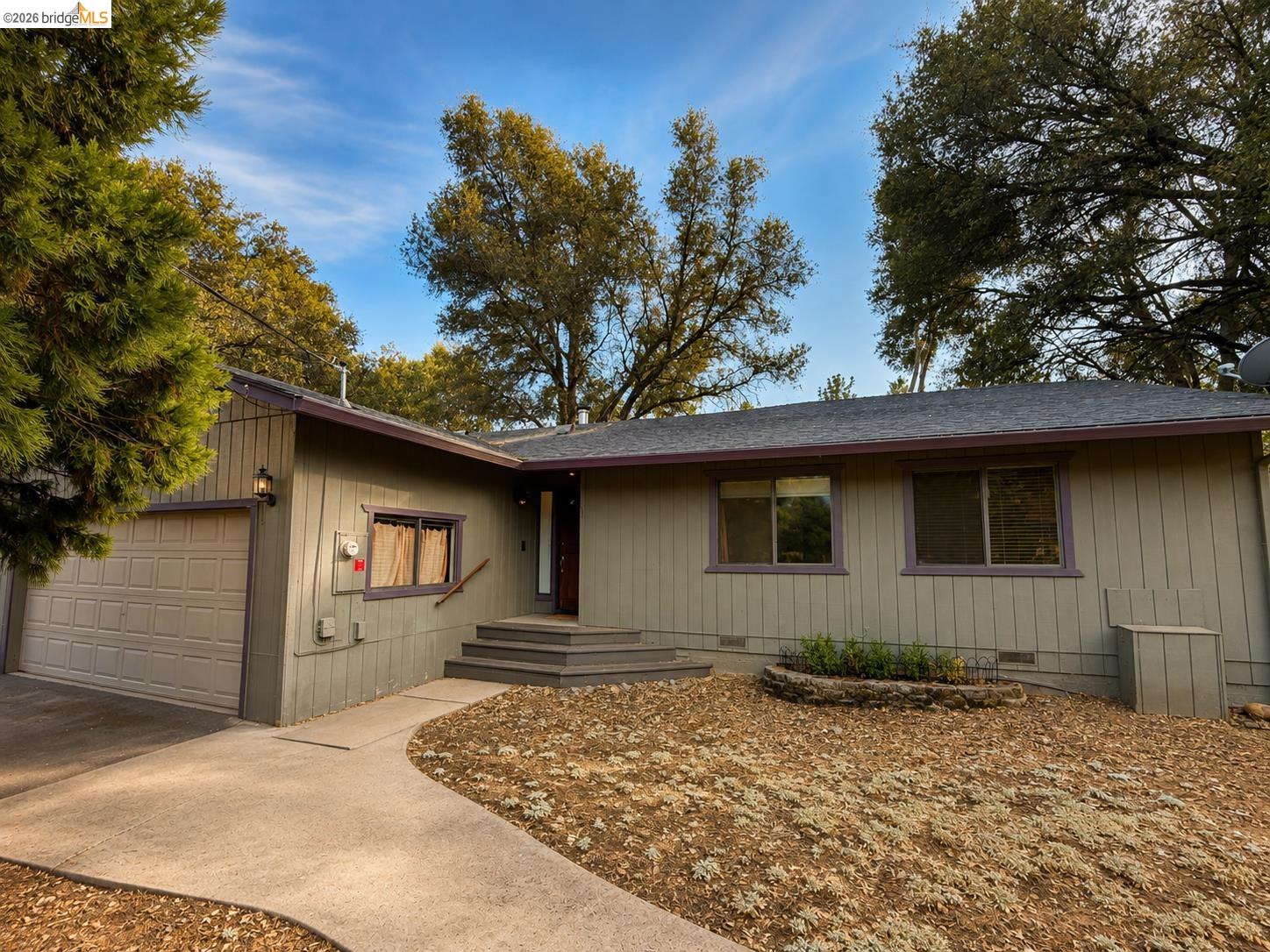 20663 Ferretti Road Groveland, CA 95321 - Photo 2 of 41 Single-story residence featuring a two-car garage, front entry steps, a paved walkway, and mature trees