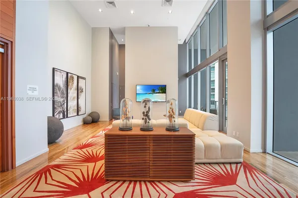 a living room with furniture a large window and a chandelier