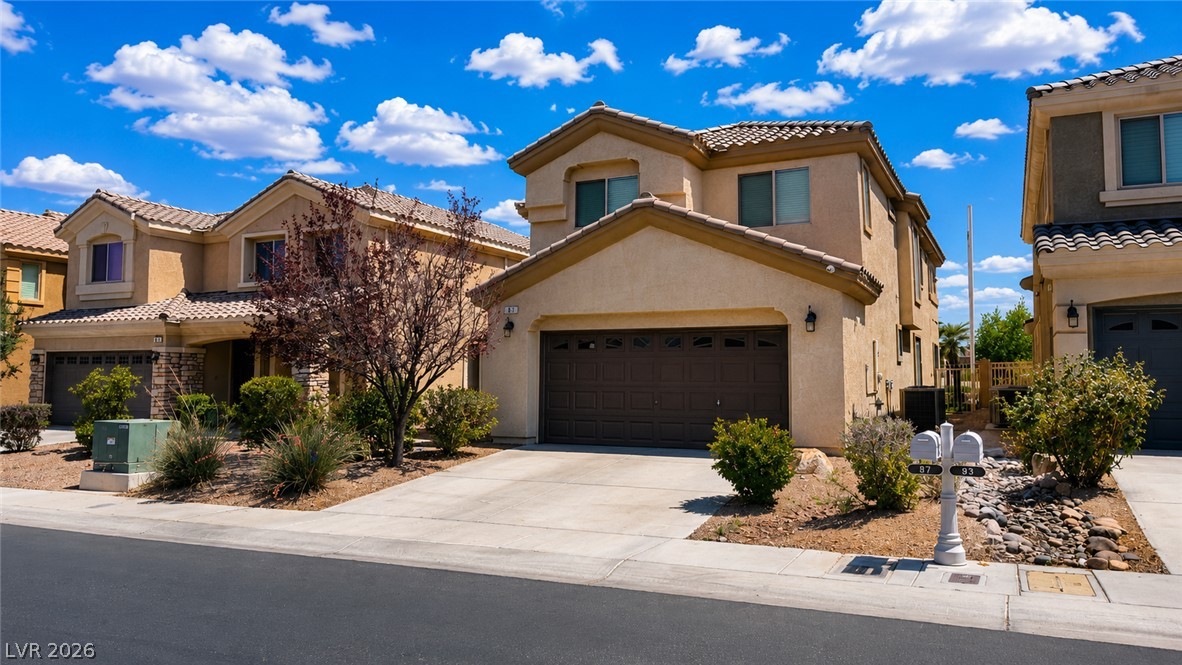 87 Tall Ruff Drive Las Vegas, NV 89148 - Photo 40 of 71 A cream-colored stucco residence, adorned with a classic tile roof, offers a welcoming facade.