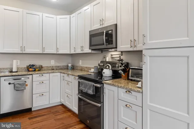 a spacious bathroom with a granite countertop sink a toilet a mirror and shower