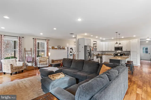 a kitchen with refrigerator a stove and a wooden floor