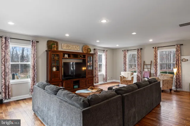 a kitchen with stainless steel appliances granite countertop a stove refrigerator and chairs