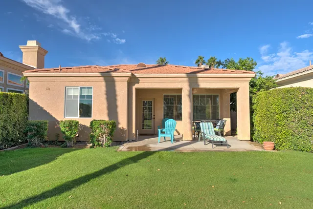 a front view of a house with garden and plants