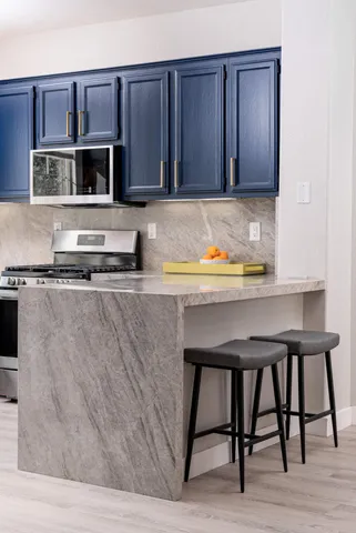 a kitchen with kitchen island stainless steel appliances and wooden cabinets