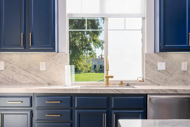 a sink with a granite countertop window and sink
