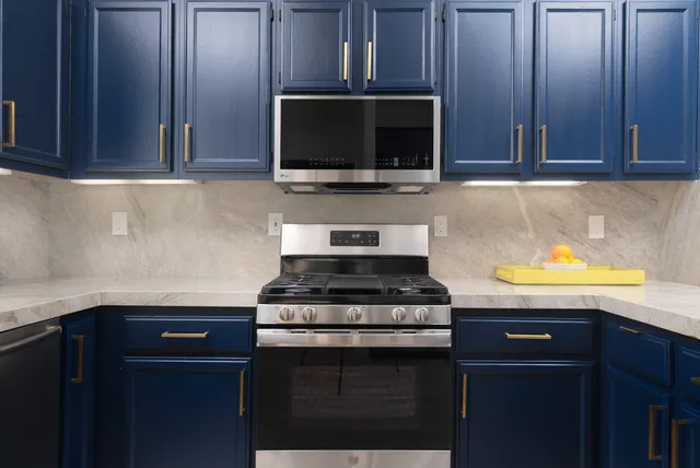 a kitchen with stainless steel appliances granite countertop a stove microwave and oven