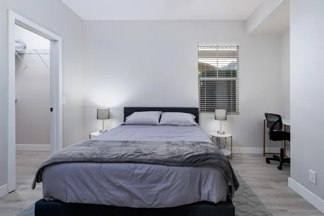 a bedroom with a bed and a large window