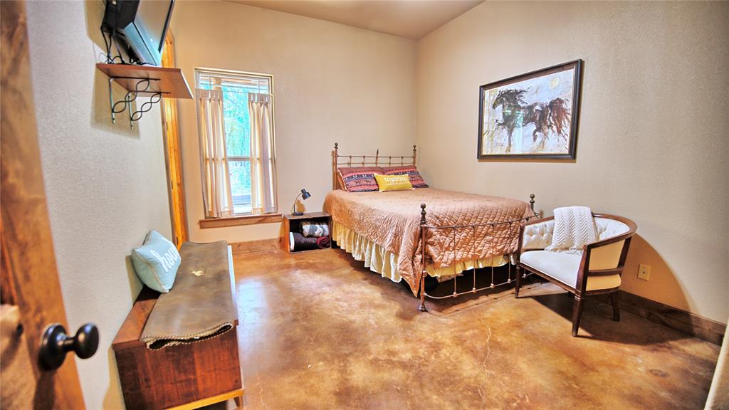 4509 Lazy E Road St. Jo, TX 76265 - Photo 28 of 39 a bedroom with a bed and wooden floor