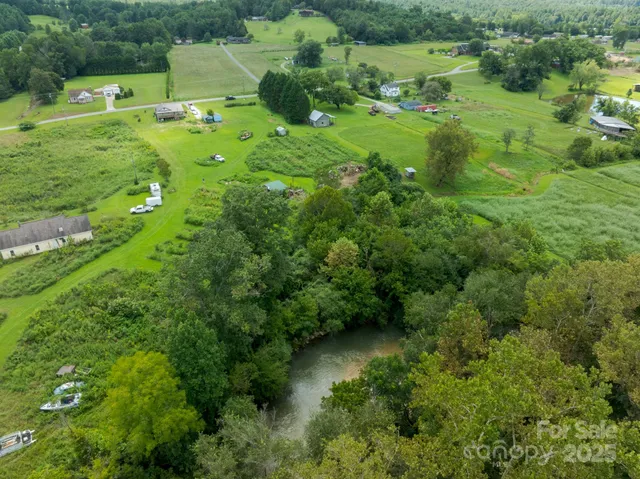 an aerial view of residential house with outdoor space and trees all around