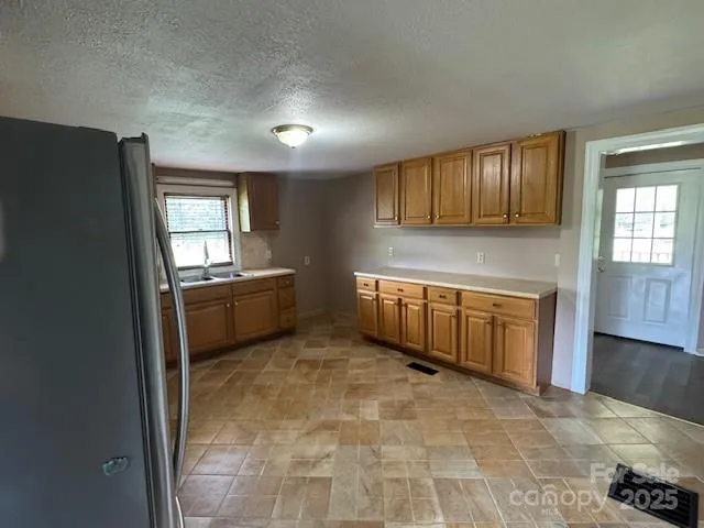 a view of a kitchen with a sink dishwasher and a refrigerator