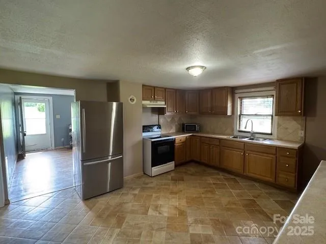 a kitchen with granite countertop a refrigerator and a sink