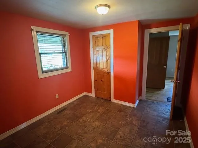 an empty room with windows and closet