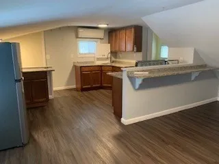 a kitchen with a sink wooden floor and a stove top oven