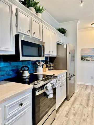 a kitchen with stainless steel appliances a sink a stove top oven a counter space and cabinets