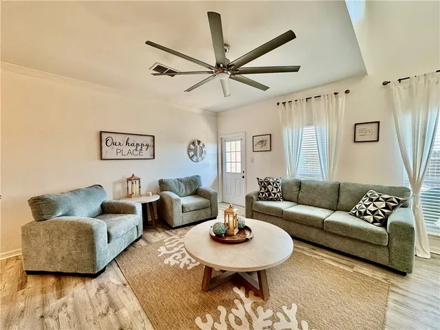 a living room with furniture and a wooden floor